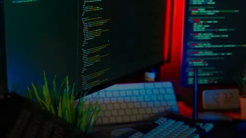 Screens display coding text, representing programming work