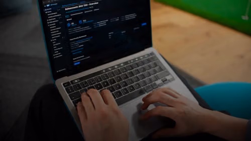 Hands typing on a laptop computer screen