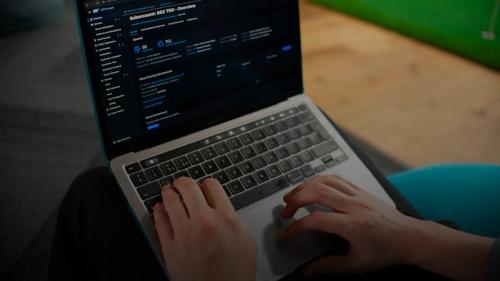 Hands typing on a laptop computer screen