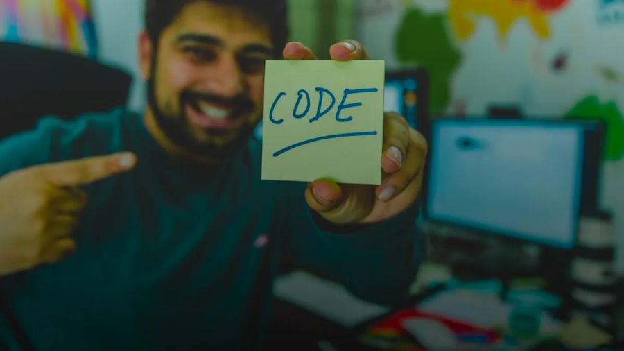 smiling man showing sticky note with code illustration