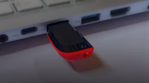 Usb flash drive plugged into a silver laptop.