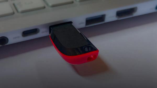 Usb flash drive plugged into a silver laptop.