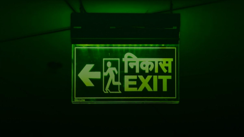 Green exit sign with arrow pointing left