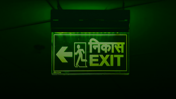 Green exit sign with arrow pointing left