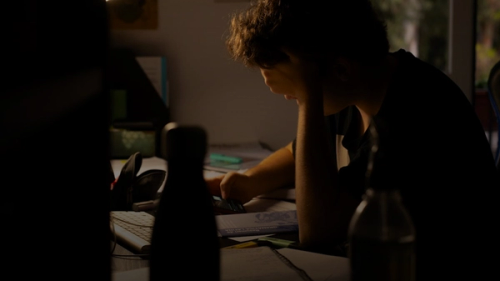 a man sitting at a desk working on a laptop computer