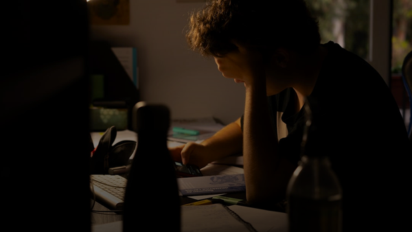 a man sitting at a desk working on a laptop computer