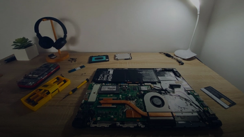 a table with a laptop and headphones on it