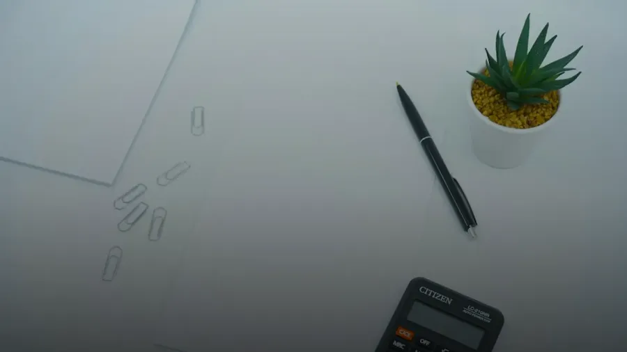 black calculator beside black pen on white printer paper