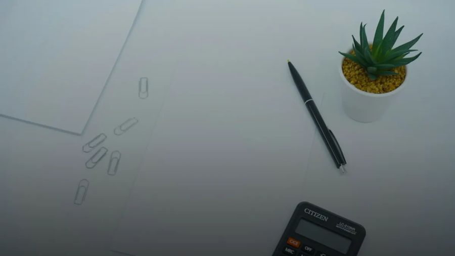 black calculator beside black pen on white printer paper