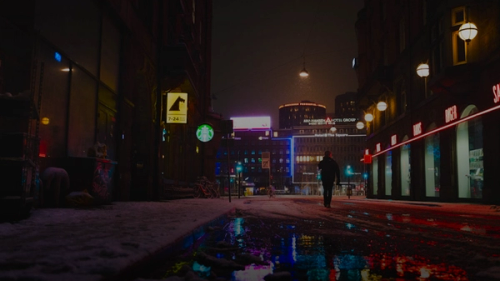 man in black jacket walking on street during night time