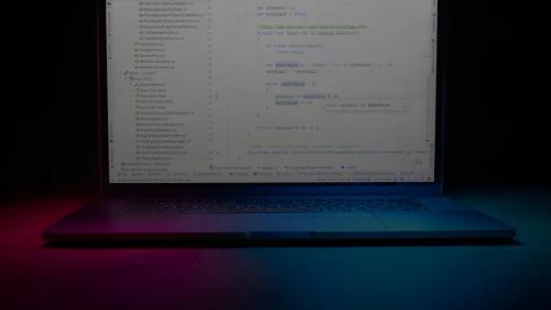 Laptop screen displaying code with colorful lighting.