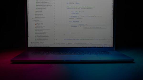 Laptop screen displaying code with colorful lighting.
