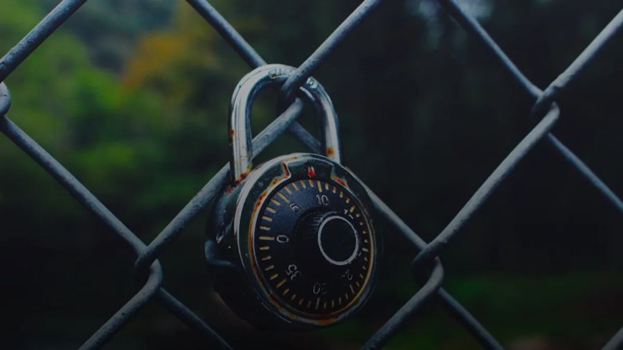 black and gray code padlock anchored on chain-link fence selective focus photo