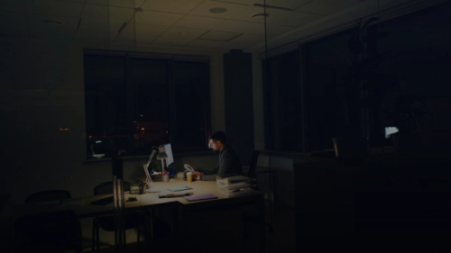 Man working late at a dimly lit office desk.