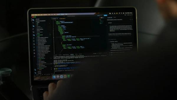 Person typing code on a laptop screen