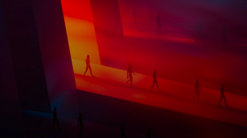 Silhouettes walking on a red illuminated runway.