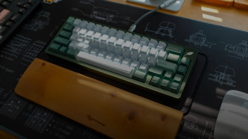 A mechanical keyboard sits on a desk mat.