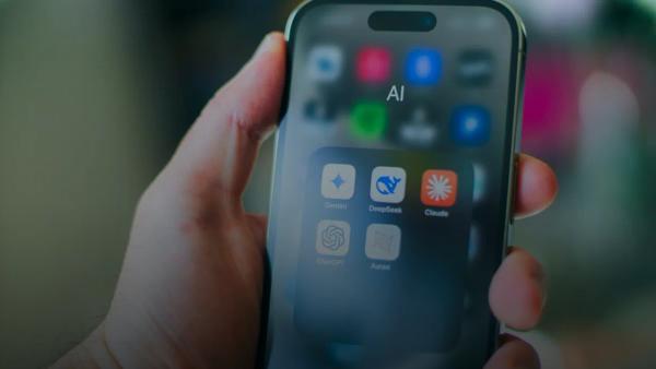 A hand holds a smartphone with various apps