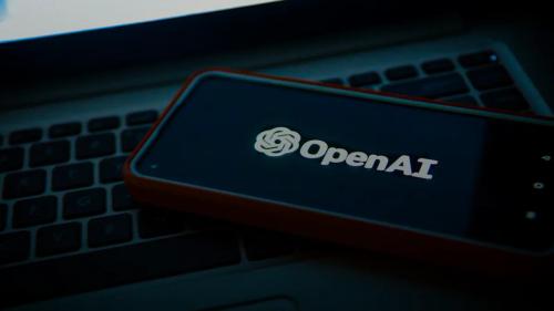 a cell phone sitting on top of a laptop computer