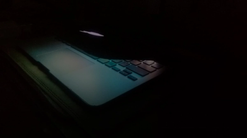 a laptop computer lit up in the dark