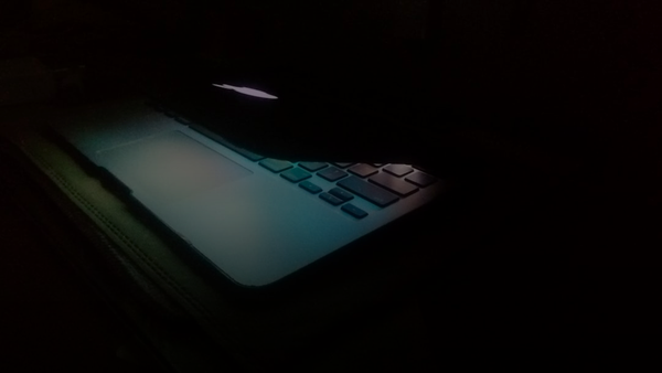 a laptop computer lit up in the dark