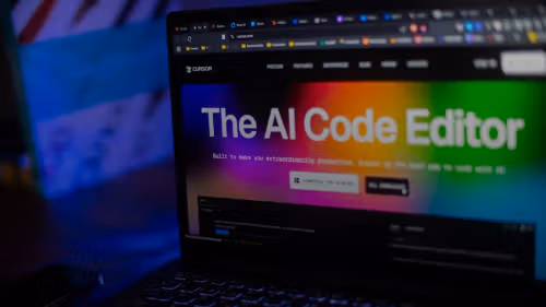 Laptop displays "the ai code editor" website.
