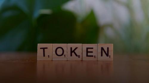 A wooden block that says token sitting on a table