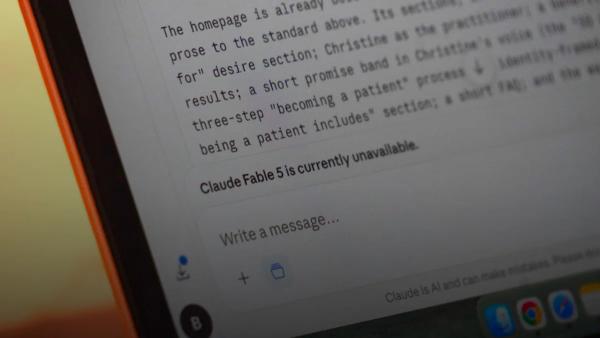 A laptop screen displays "claude fable 5 is currently unavailable."