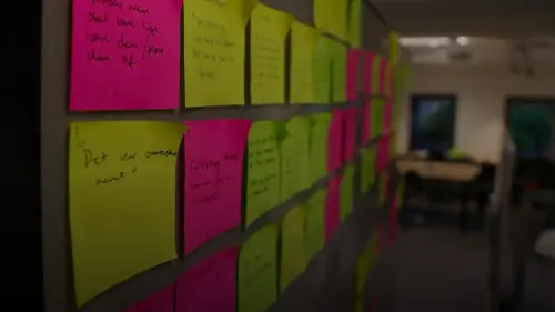 a bulletin board covered in sticky notes in an office