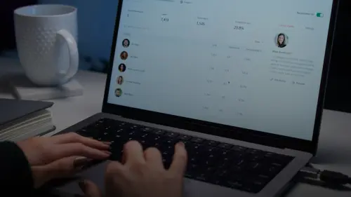 a person typing on a laptop computer on a desk