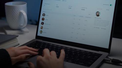 a person typing on a laptop computer on a desk