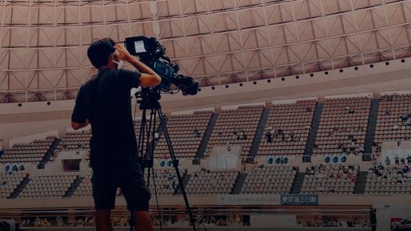 a man standing in front of a camera in a stadium