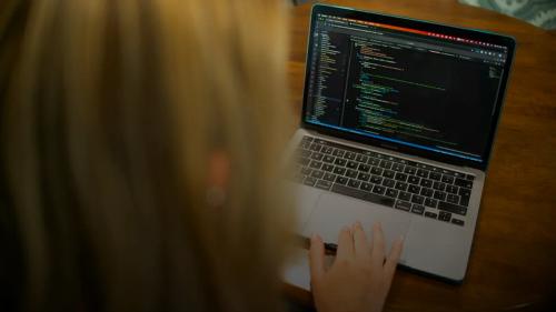 Woman typing code on a laptop computer