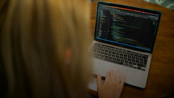 Woman typing code on a laptop computer